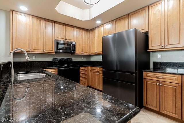 kitchen featuring sink, light tile patterned flooring, dark stone countertops, and stainless steel appliances