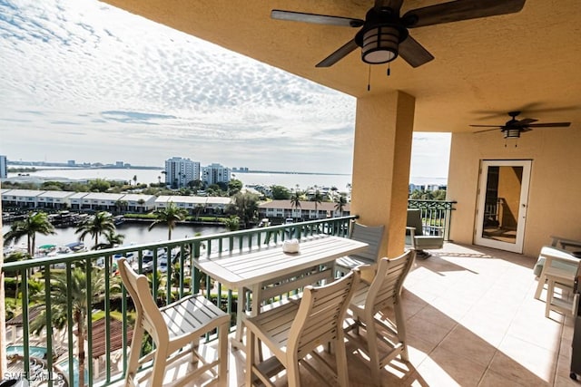 balcony featuring ceiling fan and a water view