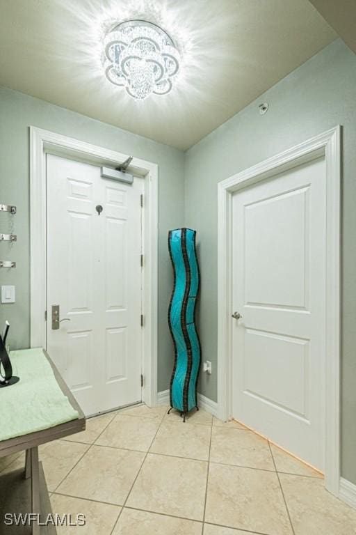 entryway with a notable chandelier and light tile patterned flooring