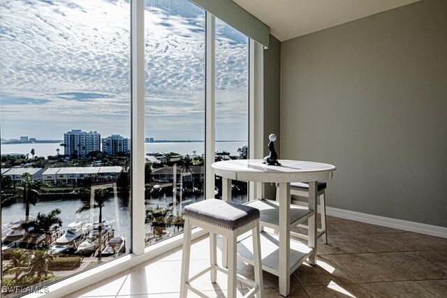 dining room with tile patterned floors and a water view