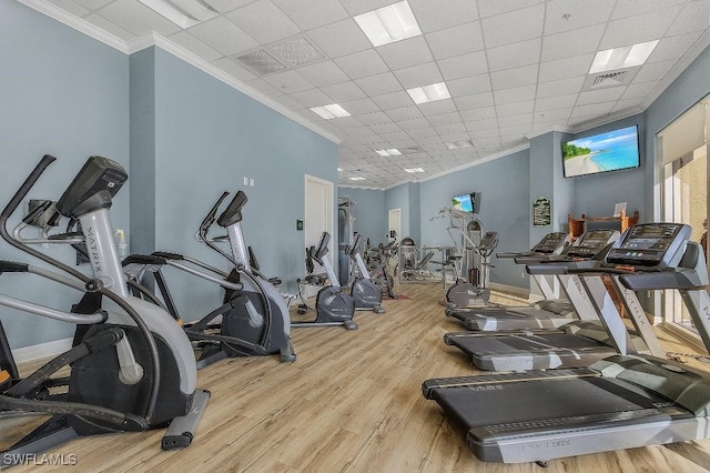 exercise room featuring a paneled ceiling, crown molding, and light hardwood / wood-style floors