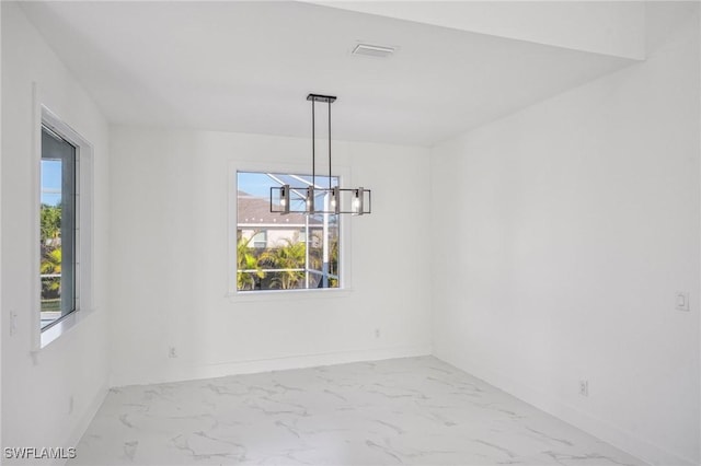 unfurnished dining area featuring a notable chandelier and plenty of natural light