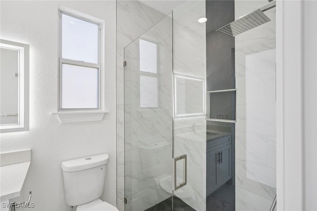 bathroom featuring vanity, toilet, and an enclosed shower