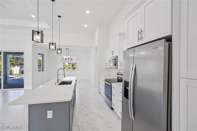 kitchen featuring light stone countertops, sink, stainless steel appliances, pendant lighting, and white cabinets