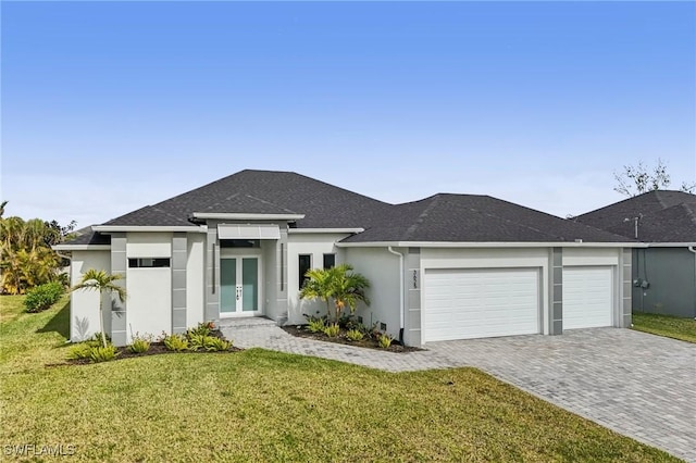 prairie-style home with french doors, a garage, and a front lawn