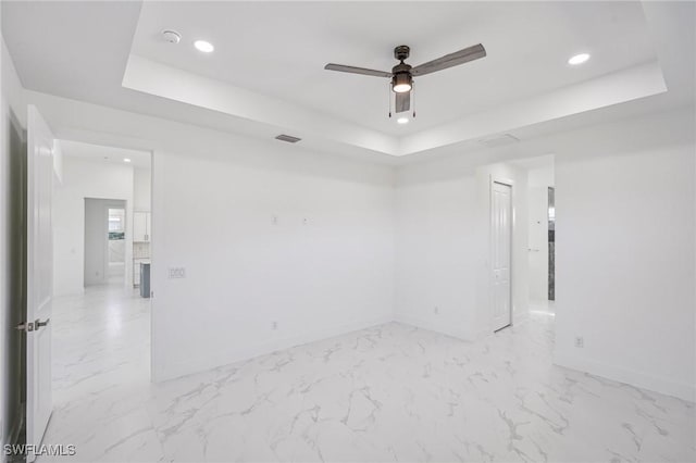 unfurnished room with a raised ceiling and ceiling fan