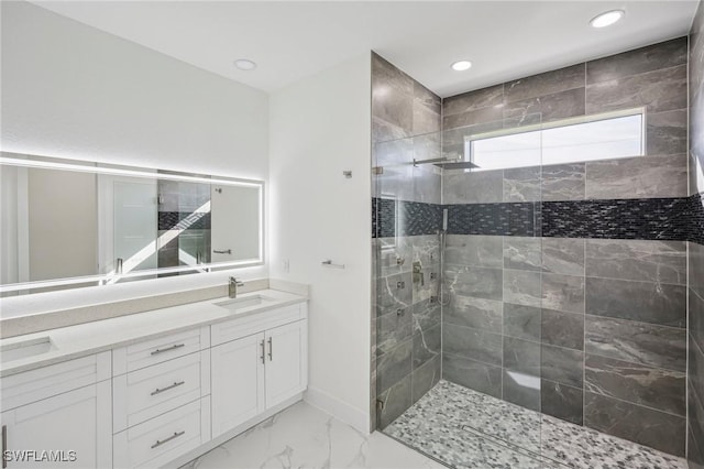 bathroom with a tile shower and vanity