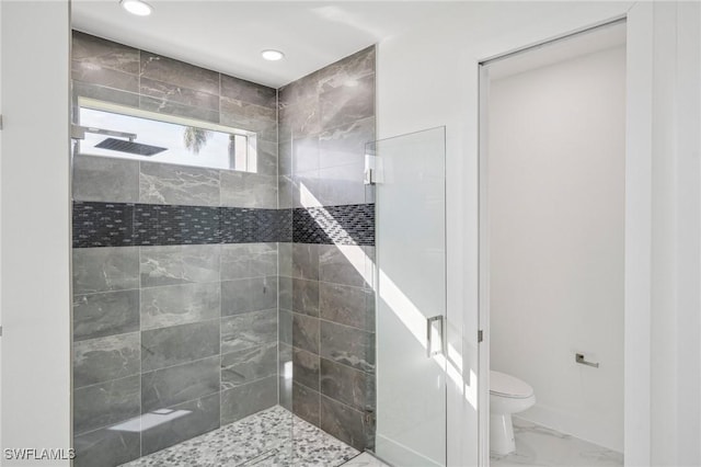 bathroom with tiled shower and toilet