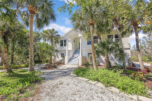 beach home with stairway and stucco siding