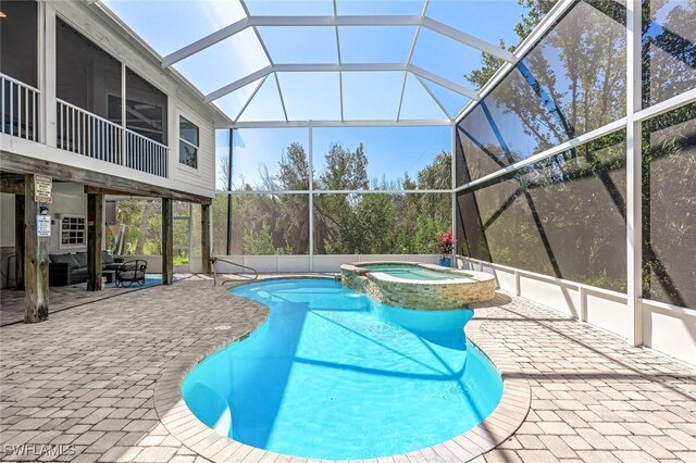 view of pool featuring a lanai, a sunroom, a patio area, and an in ground hot tub