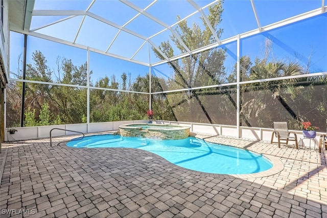 view of pool featuring a patio area, glass enclosure, and a pool with connected hot tub