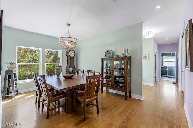 dining room with light wood-type flooring, baseboards, and a wealth of natural light