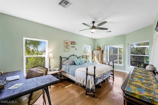 bedroom with dark wood-style flooring, visible vents, ceiling fan, and baseboards