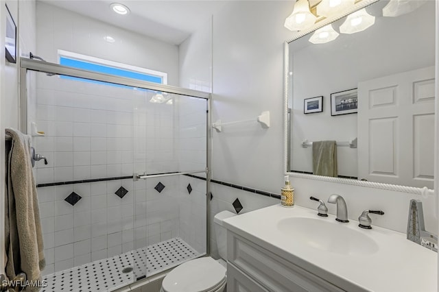 bathroom with vanity, a shower stall, and toilet