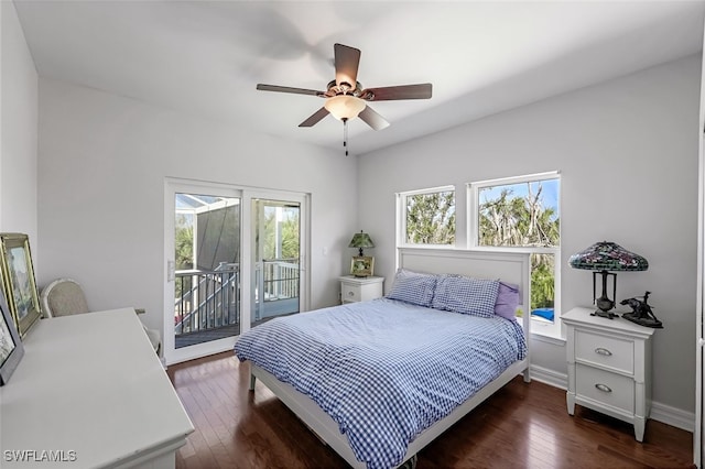 bedroom featuring access to exterior, multiple windows, dark wood finished floors, and baseboards