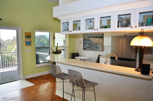 bar with dark wood-style floors, baseboards, a sink, and freestanding refrigerator