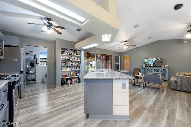 2915 Ortona Locks Rd, Moore Haven, FL 33471 - kitchen with ceiling fan, stainless steel range oven, light wood-style floors, vaulted ceiling, and open floor plan