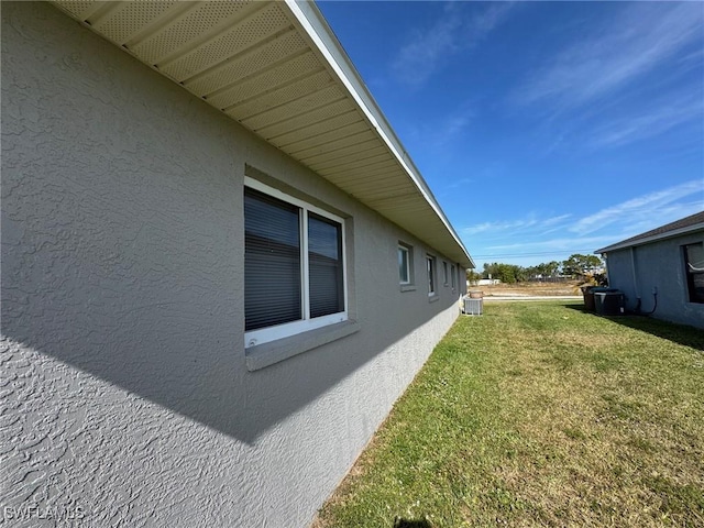 view of side of home featuring a yard and cooling unit