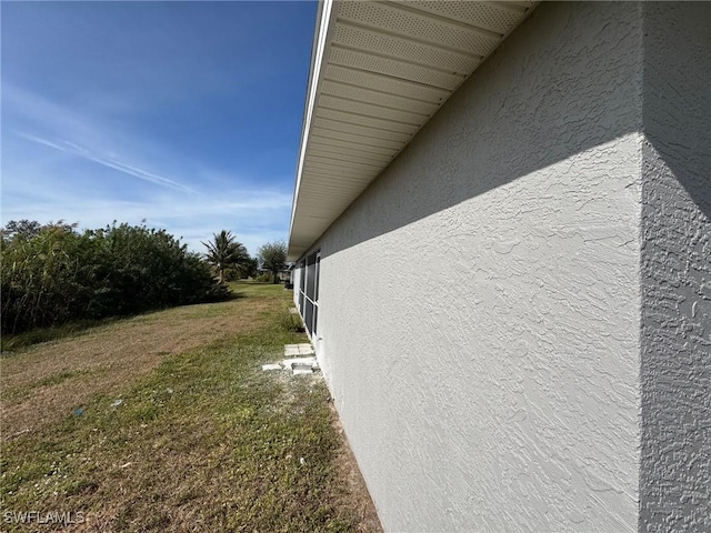 view of side of home with a yard