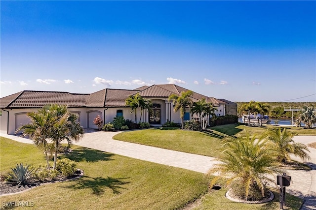 mediterranean / spanish-style house featuring a front yard and a garage