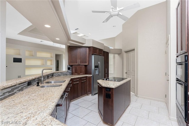 kitchen with sink, light stone counters, light tile patterned flooring, stainless steel fridge with ice dispenser, and black electric stovetop