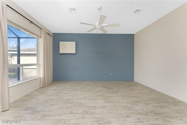 empty room with ceiling fan and light hardwood / wood-style flooring