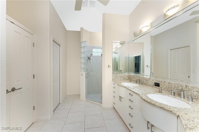 bathroom with a shower with door, vanity, tile patterned floors, and ceiling fan