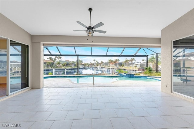 view of swimming pool featuring ceiling fan and a water view