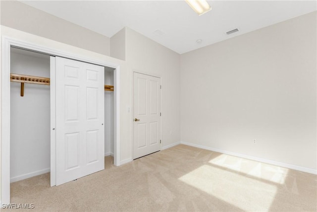 unfurnished bedroom with a closet and light carpet