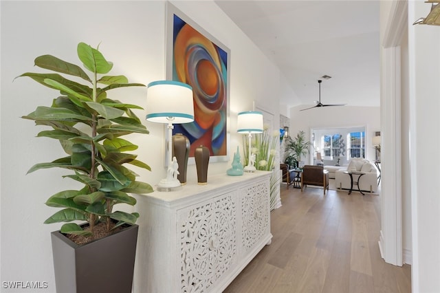 hallway featuring lofted ceiling and light hardwood / wood-style flooring