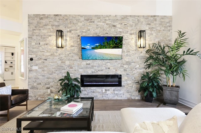 living room with a stone fireplace and hardwood / wood-style floors