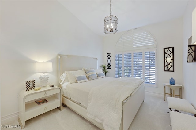 carpeted bedroom with a notable chandelier and high vaulted ceiling