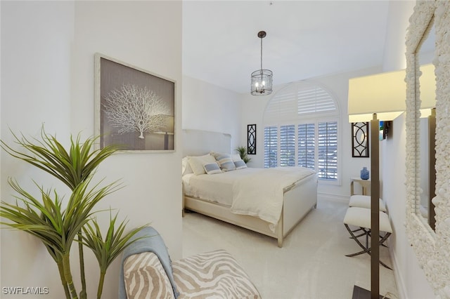 carpeted bedroom with an inviting chandelier