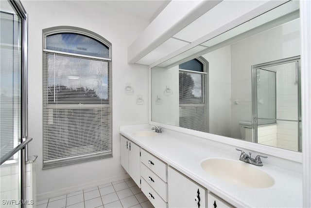 bathroom with tile patterned floors, a shower with door, and vanity