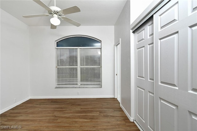 empty room with ceiling fan and dark hardwood / wood-style floors