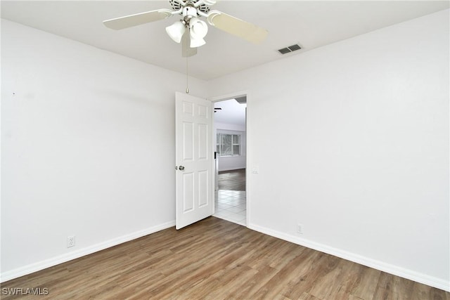 empty room with hardwood / wood-style floors and ceiling fan