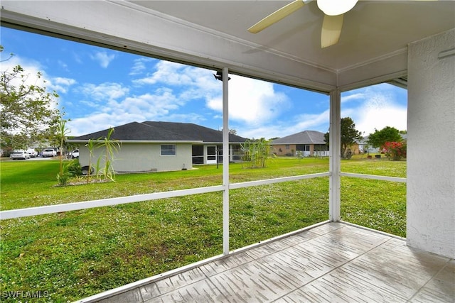 unfurnished sunroom with ceiling fan