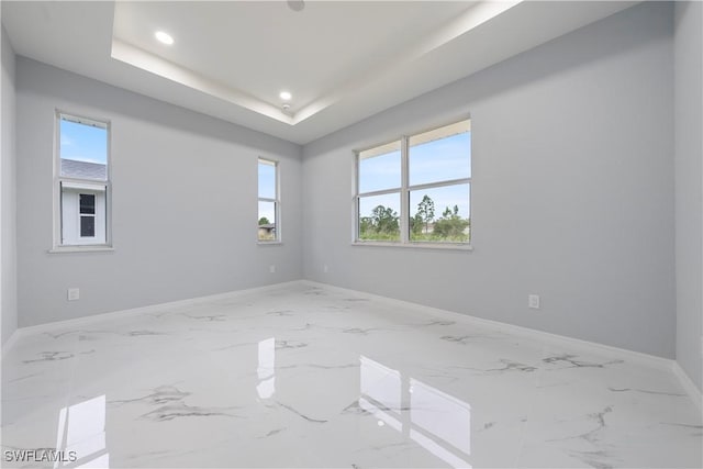 unfurnished room featuring a tray ceiling