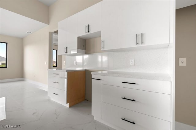 kitchen featuring tasteful backsplash and white cabinetry