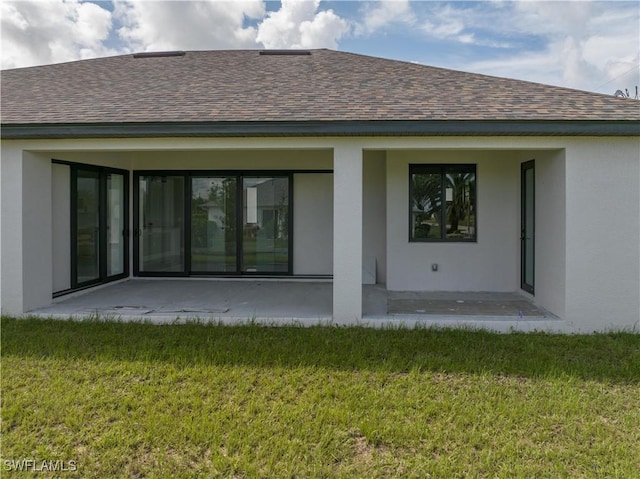 rear view of house featuring a patio area and a yard