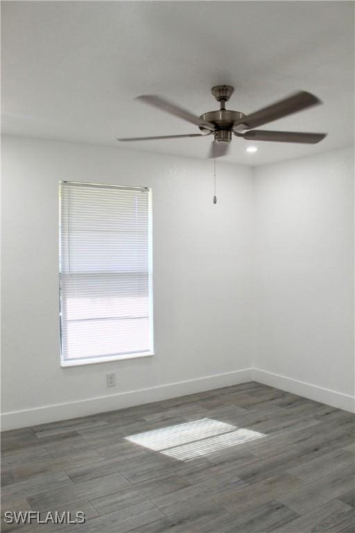 spare room with dark hardwood / wood-style floors and ceiling fan