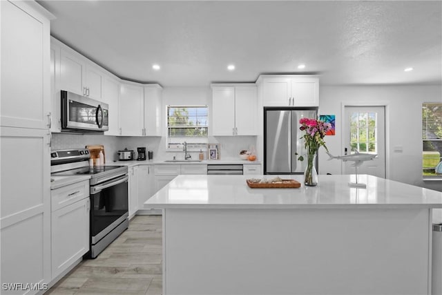 kitchen with a healthy amount of sunlight, appliances with stainless steel finishes, light countertops, and a sink