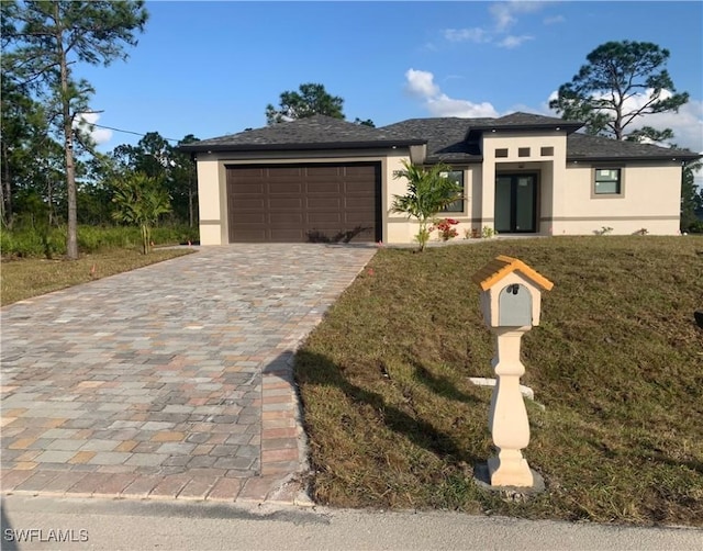 prairie-style home with a front lawn and a garage