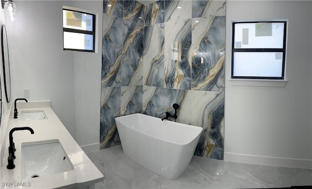 bathroom with a bathing tub, vanity, and tile walls