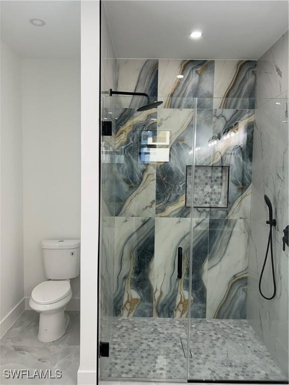 bathroom with a shower with door and toilet