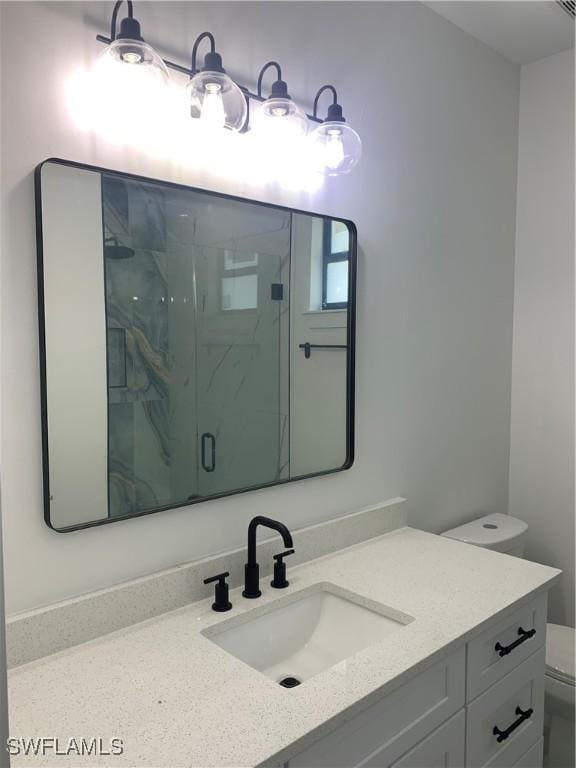 bathroom with vanity, an enclosed shower, and toilet