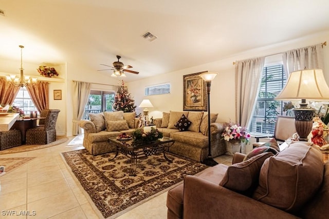 living room featuring ceiling fan with notable chandelier and light tile patterned flooring