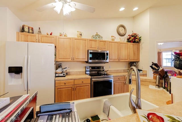 kitchen with ceiling fan, light brown cabinetry, vaulted ceiling, and appliances with stainless steel finishes