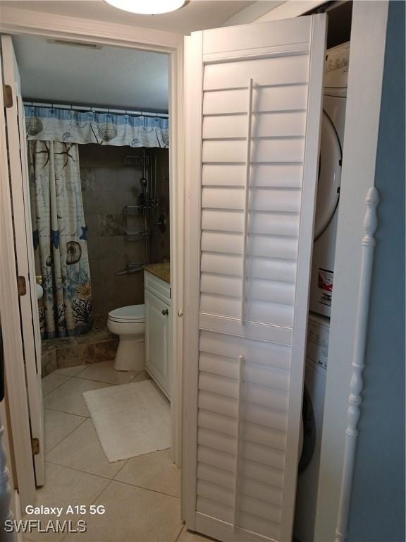 bathroom featuring tile patterned flooring, vanity, toilet, and curtained shower