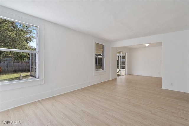 empty room featuring a wealth of natural light and light hardwood / wood-style flooring